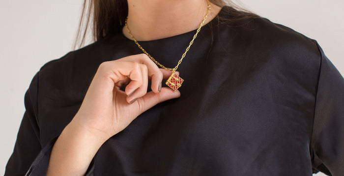 Girl in a black shirt holding out a Burgundy Secret Diary Book Locket
